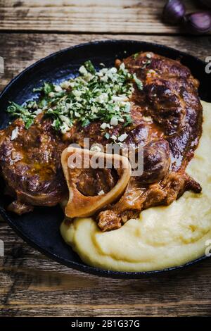 Osso buco avec gremolata, condiment de hacher le cilantro, l'ail, et le zeste de citron, servi avec polenta. Cuisine italienne traditionnelle Banque D'Images