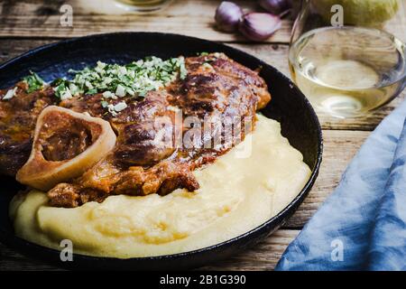 Osso buco avec gremolata, condiment de hacher le cilantro, l'ail, et le zeste de citron, servi avec polenta. Cuisine italienne traditionnelle Banque D'Images