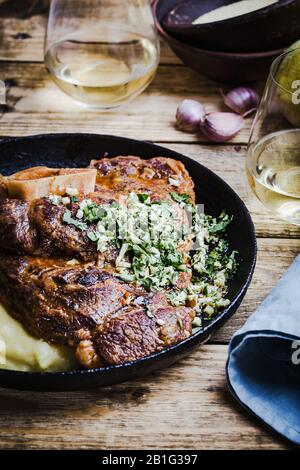 Osso buco avec gremolata, condiment de hacher le cilantro, l'ail, et le zeste de citron, servi avec polenta. Cuisine italienne traditionnelle Banque D'Images