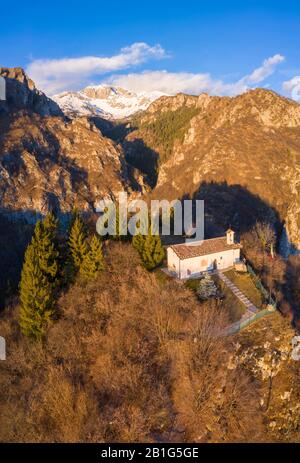 Vue aérienne de la petite église appelée San Peder et le Presolana pendant un coucher de soleil d'hiver. Rusio, Castione Della Presolana, Val Seriana, Bergame Distr Banque D'Images