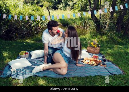 Jeune couple joueur ayant pique-nique dans le parc de la ville, Il porte le nez rouge Selective focus Banque D'Images