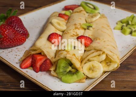 Crêpes saines avec fruits, banane, kiwi et fraise. Petit déjeuner français sain Banque D'Images