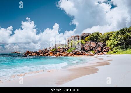 Plage tropicale de la Grande Anse à la Digue, Seychelles. Célèbres formations rocheuses de granit et nuages blancs au-dessus Banque D'Images
