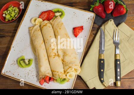 Crêpes saines avec fruits, banane, kiwi et fraise. Petit déjeuner français sain Banque D'Images