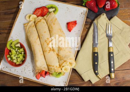 Crêpes saines avec fruits, banane, kiwi et fraise. Petit déjeuner français sain Banque D'Images