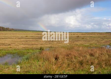 Rainbow et nuages de pluie sur les marais. Prise Octobre. Loch Gruinart, Île D'Islay, Argyll, Écosse, Royaume-Uni. Banque D'Images