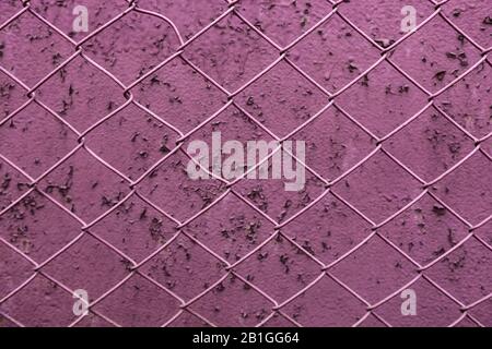 Maillage en fer avec paroi d'arrière-plan rose foncé. Texture de la paroi. Fond D'Écran. Banque D'Images