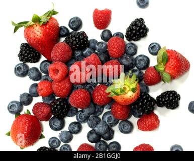 Les baies douces se mélangent sur fond blanc. Framboises mûres, bleuets et mûres. Banque D'Images