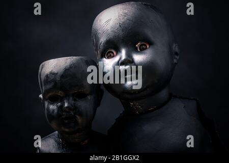 Paire de poupées creepy dans le noir Banque D'Images