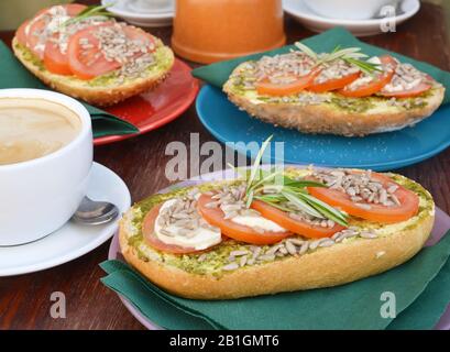 Sandwichs avec houmous et tomate sur une table avec une tasse de café Banque D'Images