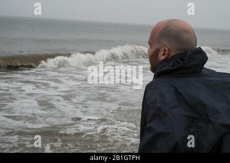 Cape Henloopen, Delaware, États-Unis. 25 février 2020. Dave WHITSON regarde l'océan Atlantique depuis la plage de Cape Henloopen, DE quand il commence sa promenade côte à côte à travers l'Amérique le 25 février 2020. Whitson, un professeur d'histoire du lycée de Portland, Oregon, marche pour rencontrer et parler avec les gens le long de sa route pour mieux comprendre et connecter l'Amérique rurale. Whitson est un marcheur expérimenté de longue distance et s'attend à terminer sa promenade côte à côte en août. Crédit: Fritz Nordengren/Zuma Wire/Alay Live News Banque D'Images