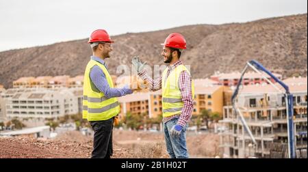 Les bâtisseurs sur le chantier de construction résidentielle faisant une affaire - Les travailleurs Heureux sont satisfaits de leur plan - Affaire, immobilier, ingénieur, industriel et b Banque D'Images