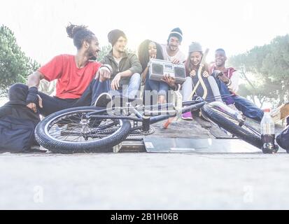 Des amis heureux écoutant de la musique dans le parc de la ville - Breaker, les patineurs et les amateurs de freestyle s'amuser ensemble - concept de gens de culture divers profitant de tim Banque D'Images