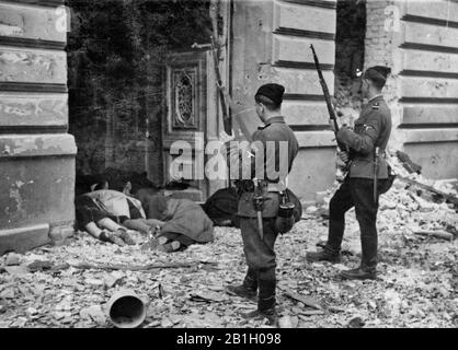 Deux "Askaris" ou "Trawnikis" comme représentants des soi-disant "divisions ethniques filiales étrangères" SS avant les cadavres des Juifs à l'entrée du ghetto de Varsovie. L'unité formée dans le village de Trawniki était composée d'Ukrainiens, de Russes, de Belorussiens, de Polonais, d'Estoniens, de Lituaniens, de Lettons, d'Allemands ethniques, de Kazakhstan et de Tartars. 1943 Banque D'Images