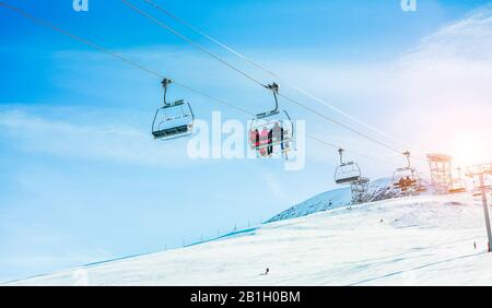 Les gens qui se trouvent sur les remontées mécaniques de la station de ski d'hiver - vacances, location d'équipement de neige, ski, snowboard et paysage de montagne - se concentrer sur les gars assis Banque D'Images