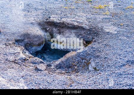 Source chaude bouillante avec de la vapeur chaude qui s'élève hors du trou dans le sol. Banque D'Images