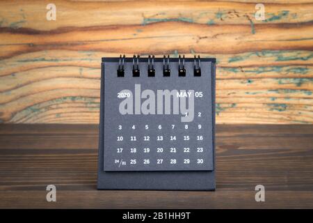 2020 Mai. Calendrier en papier noir sur une table en bois. Planification de l'heure, comptage de jour et jours fériés. Banque D'Images