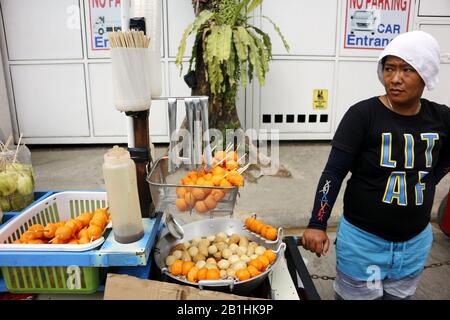 Taytay, Rizal, Philippines - 20 février 2020: Le vendeur de nourriture de rue vend des en-cas favoris philippins appelés Kwek Kwek ou des œufs de caille frits profonds à elle Banque D'Images