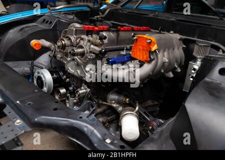 Puissant moteur à essence à réglage avec un turbocompresseur et un chargeur dans le compartiment moteur de la voiture avec un capot ouvert dans une réparation de voiture et des améliorations Banque D'Images