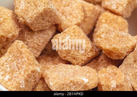 Cubes de sucre de canne brun isolé sur fond blanc Banque D'Images