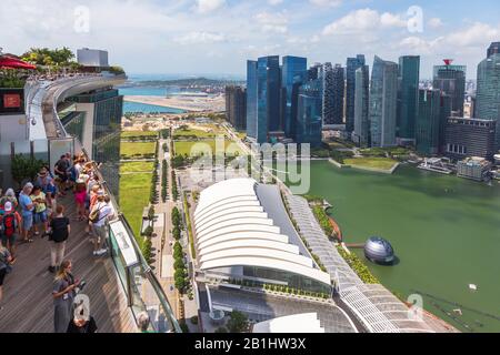 Touristes sur la terrasse d'observation de l'hôtel Marina Bay Sands surplombant Marina Bay vers le quartier des affaires de Singapour, en Asie Banque D'Images