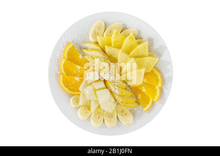 Plaque avec différents fruits tranchés isolé plaques fond blanc, saupoudrée de sucre en poudre. Dessert pour un menu dans un café, restaurant, café sh Banque D'Images