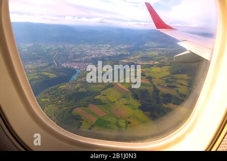 Vue aérienne depuis l'avion, la vallée verte de la Suisse, le village et la rivière bleue Banque D'Images