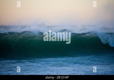 Vagues sur la plage dans un beau coucher de soleil Banque D'Images