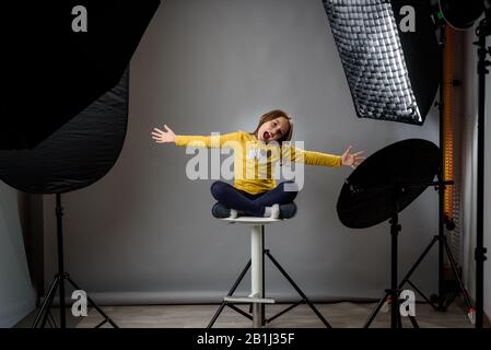 Photographier des enfants dans un studio photo professionnel avec un équipement d'éclairage. Enfant fille pose pour des photos professionnelles avec des flashs modernes, vitesse l Banque D'Images