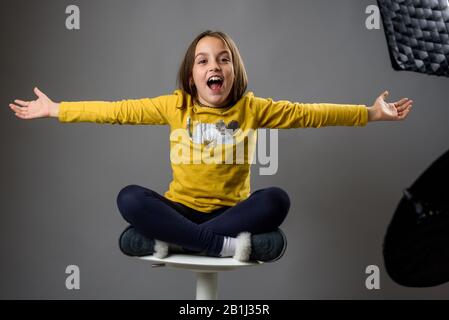 Photographier des enfants dans un studio photo professionnel avec un équipement d'éclairage. Enfant fille pose pour des photos professionnelles avec des flashs modernes, vitesse l Banque D'Images