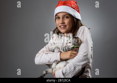 Portrait of happy young little girl avec calico kitten cat. Portrait d'un joyeux petit enfant girl holding tricolor diluer calico kitty sur un profes Banque D'Images