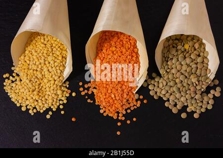 Lentilles jaunes, rouges et vertes dans des sacs de papyrus. Banque D'Images