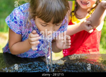 Les enfants boivent l'eau d'une source à Borjomi (Géorgie). Focus sélectif. Banque D'Images