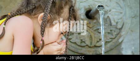 Les enfants boivent l'eau d'une source à Borjomi (Géorgie). Focus sélectif. Banque D'Images