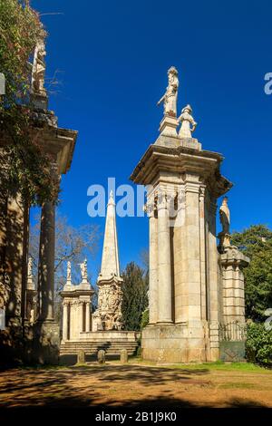 Colonnes, statues et fontaine centrale avec obélisque au sanctuaire de Nossa Senhora dos Remédios, au Portugal, sur fond bleu du ciel. Banque D'Images