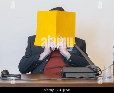 Hambourg, Allemagne. 26 février 2020. Le défendeur cache son visage derrière une couverture de dossier lorsqu'il siège dans la salle d'audience. Selon le ministère public, il était en service en tant que jeune homme dans le camp de concentration de Stutthof près de Danzig d'août 1944 à avril 1945. L'affaire sera entendue devant le tribunal pour mineurs. (Az. 617 Ks 10/19 Pichet.) Crédit: Markus Scholz/Dpa/Alay Live News Banque D'Images