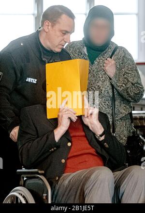 Hambourg, Allemagne. 26 février 2020. Le défendeur cache son visage derrière une couverture de dossier lorsqu'il est poussé dans la salle d'audience dans un fauteuil roulant. Selon le ministère public, il était en service en tant que jeune homme dans le camp de concentration de Stutthof près de Danzig d'août 1944 à avril 1945. L'affaire sera entendue devant le tribunal pour mineurs. (Az. 617 Ks 10/19 pichet.) crédit: Markus Scholz/dpa - ATTENTION: Personne(s) a (ont) été pixellisé pour des raisons juridiques/dpa/Alay Live News Banque D'Images