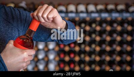 l'homme ouvre une bouteille de vin avec une fermeture à vis au taster dans la salle d'exposition Banque D'Images