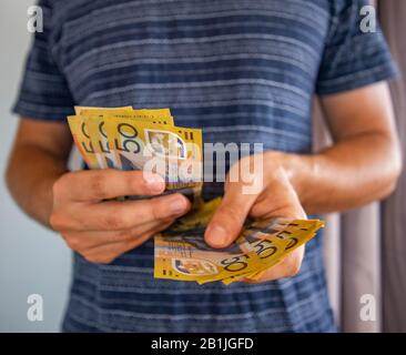 Dans cette illustration photo, un homme détient des notes australiennes de cinquante dollars. Banque D'Images