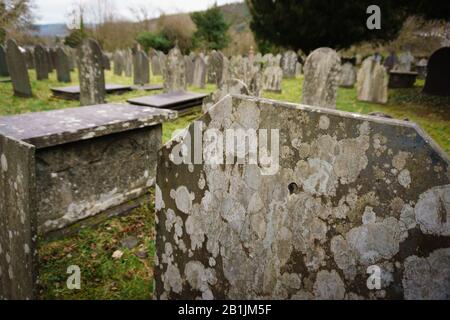 Vieux lichen couvert de pierres graves ou de marqueurs dans la campagne Cimetière de l'église Saint Michaels à Betws y Coed North Pays de Galles Royaume-Uni Banque D'Images