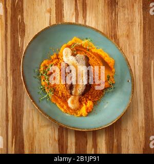 cuisine marocaine, plat cous sur une plaque avec sauce, décoré avec salade sur une table en bois et espace de copie pour le texte Banque D'Images