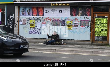 Buveur de rue avec des bouteilles à côté de lui mendiant dans London Road Brighton Banque D'Images