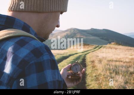 Homme avec un vieux compas à portée de main sur la route des montagnes. Concept de voyage. Photographie de paysage Banque D'Images