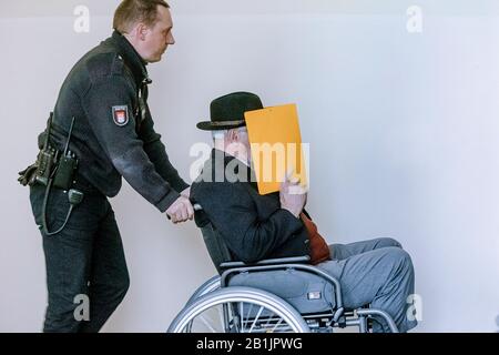 Hambourg, Allemagne. 26 février 2020. Le défendeur cache son visage derrière une couverture de dossier lorsqu'il est sorti de la salle d'audience dans un fauteuil roulant pendant une pause dans la procédure. Selon le ministère public, il était en service en tant que jeune homme dans le camp de concentration de Stutthof près de Danzig d'août 1944 à avril 1945. L'affaire sera entendue devant le tribunal pour mineurs. (Az. 617 Ks 10/19 Pichet.) Crédit: Markus Scholz/Dpa/Alay Live News Banque D'Images