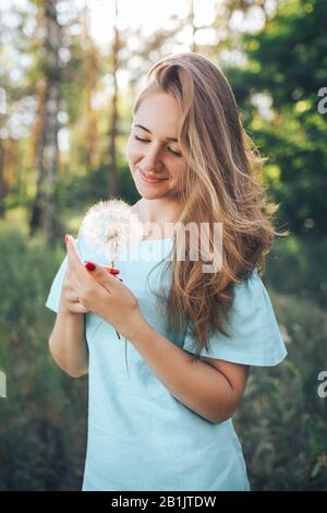 Belle fille avec de longs cheveux dans une forêt au coucher du soleil Banque D'Images