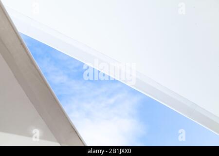 Les auvents en forme de voile blanc sont sous le ciel bleu vif, photo d'arrière-plan abstraite Banque D'Images