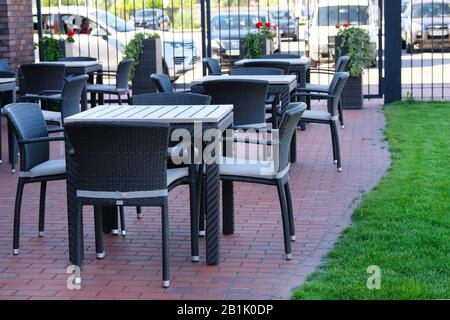 Terrasse à café vide avec tables et chaises en rotin Banque D'Images