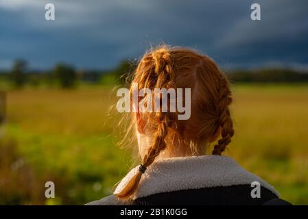 Une Fille Aux Cheveux Rouges Qui Fait Du Wallaing Dans La Nature Avec Des Nuages De Soleil Et De Tempête Banque D'Images