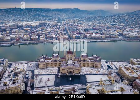 Budapest, Hongrie - vue aérienne du Parlement enneigé de Hongrie en hiver avec le Danube et le bastion des pêcheurs en arrière-plan Banque D'Images