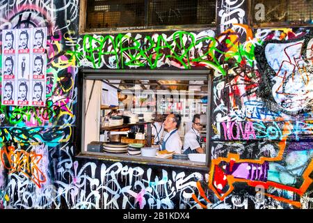 Ouverture de la fenêtre pour servir des plats à emporter au restaurant dans une allée peinte au graffiti, Hosier Street, Melbourne Lanes, Melbourne, Victoria, Australi Banque D'Images